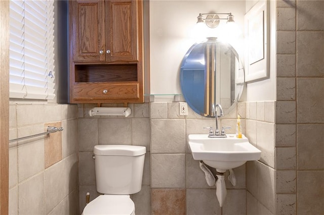 bathroom featuring toilet and tile walls