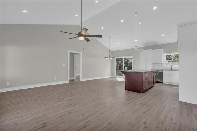 kitchen with dishwasher, white cabinets, light hardwood / wood-style flooring, high vaulted ceiling, and ceiling fan