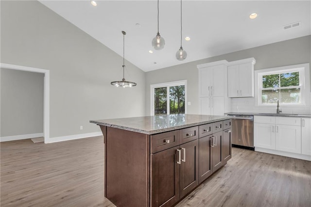 kitchen with light hardwood / wood-style flooring, white cabinets, dishwasher, and decorative light fixtures