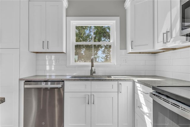 kitchen with stainless steel appliances, white cabinetry, tasteful backsplash, and sink