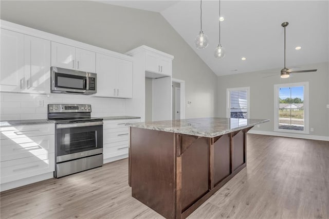 kitchen featuring white cabinets, a center island, appliances with stainless steel finishes, and hanging light fixtures