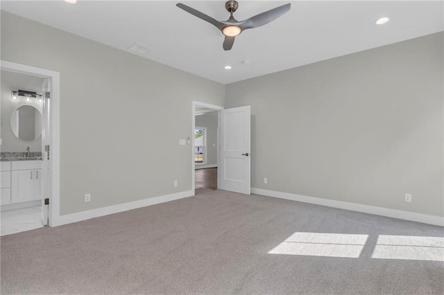 unfurnished bedroom with ceiling fan, sink, connected bathroom, and light carpet