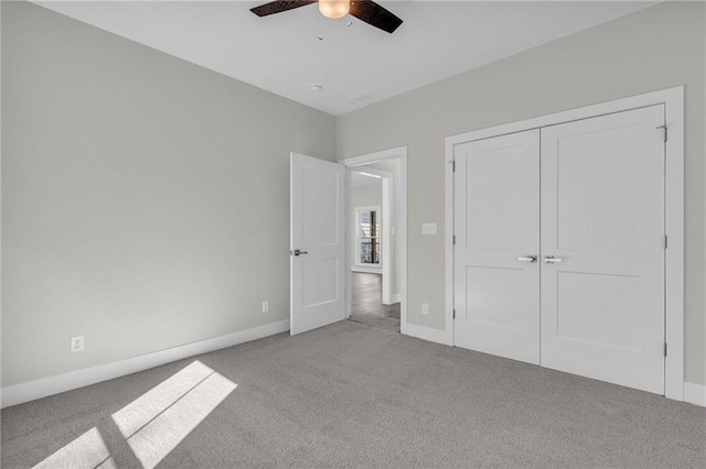 unfurnished bedroom featuring ceiling fan, light colored carpet, and a closet