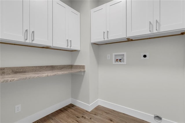 laundry room with washer hookup, electric dryer hookup, light hardwood / wood-style flooring, and cabinets