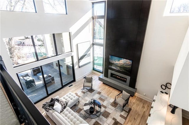 living room with light hardwood / wood-style flooring and a high ceiling