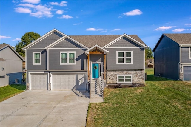 bi-level home featuring a garage and a front lawn