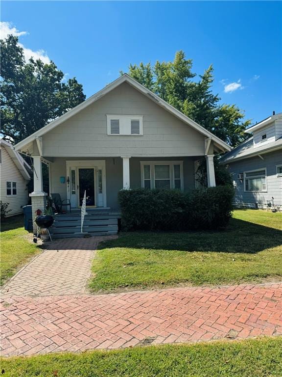 bungalow-style home with a front yard and a porch