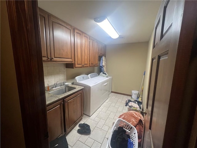 clothes washing area featuring sink, cabinets, and separate washer and dryer