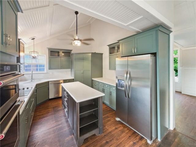 kitchen featuring appliances with stainless steel finishes, hanging light fixtures, ceiling fan with notable chandelier, a kitchen island, and green cabinetry