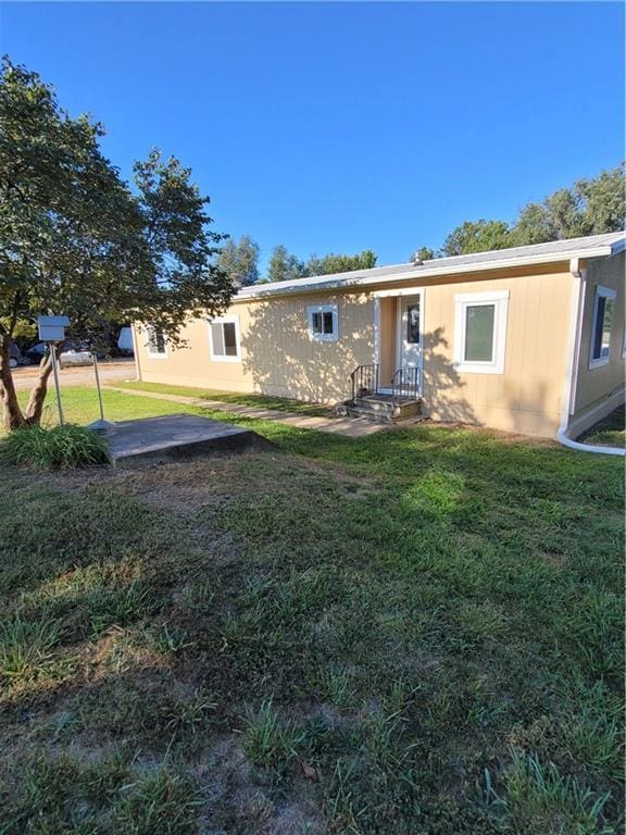 back of property featuring a patio and a yard