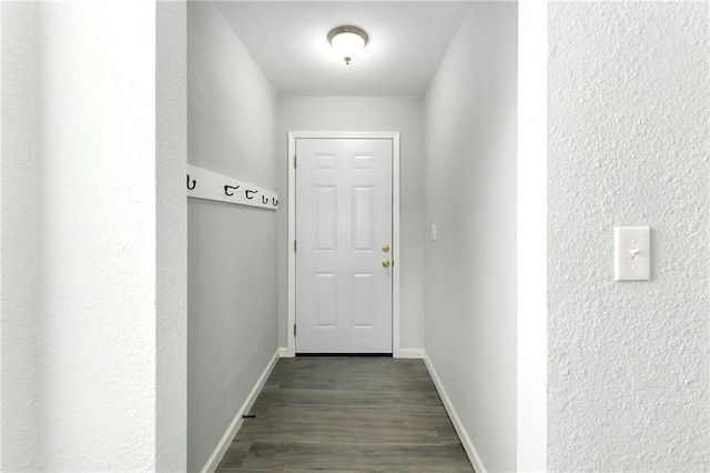 hall featuring a textured ceiling and dark hardwood / wood-style flooring