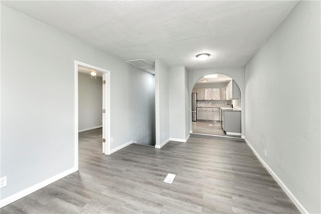 empty room with a textured ceiling and dark wood-type flooring