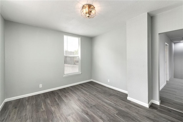 spare room featuring dark wood-type flooring