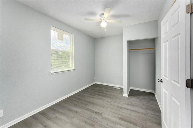 unfurnished bedroom featuring ceiling fan, a closet, and wood-type flooring