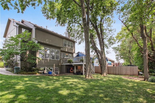 rear view of property with a yard and a deck