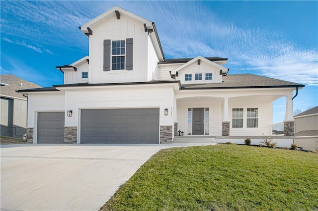 view of front of property featuring an attached garage, concrete driveway, board and batten siding, and a front yard