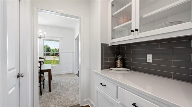 bar featuring dark colored carpet, crown molding, and backsplash