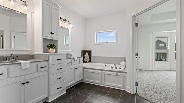 bathroom featuring tile patterned flooring, vanity, and a bath