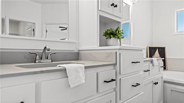 full bathroom featuring a tub to relax in and vanity