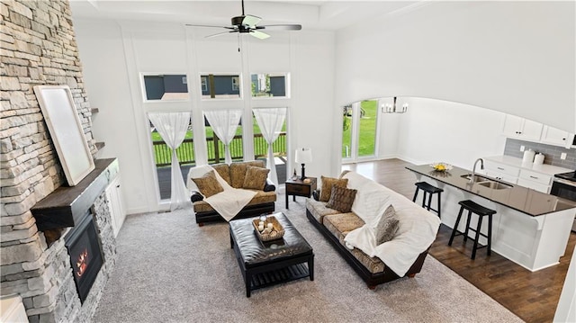 living area with arched walkways, a high ceiling, dark wood-style flooring, and a fireplace