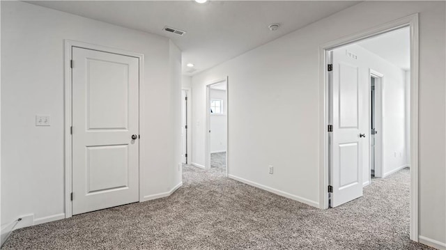 carpeted empty room featuring recessed lighting, visible vents, and baseboards