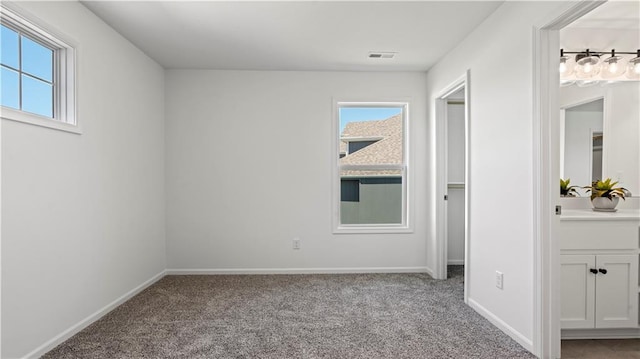 unfurnished bedroom featuring carpet, visible vents, and baseboards