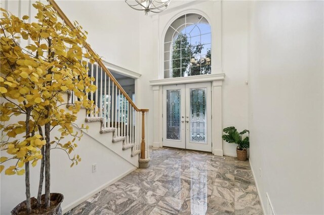 entrance foyer featuring french doors and a high ceiling