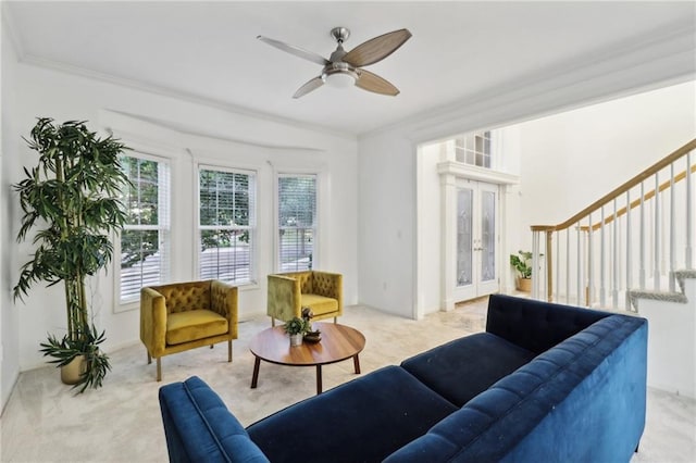 living room featuring light carpet, crown molding, and ceiling fan