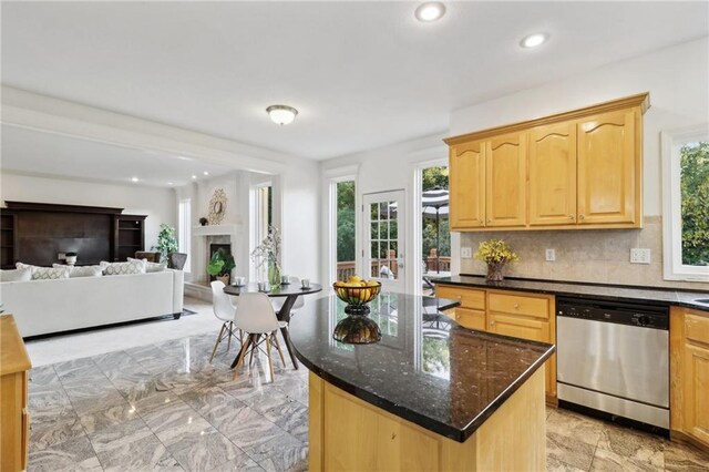 kitchen featuring dark stone countertops, dishwasher, tasteful backsplash, and a healthy amount of sunlight