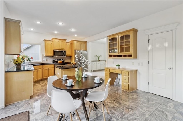 kitchen featuring light brown cabinetry, stainless steel appliances, sink, and a center island