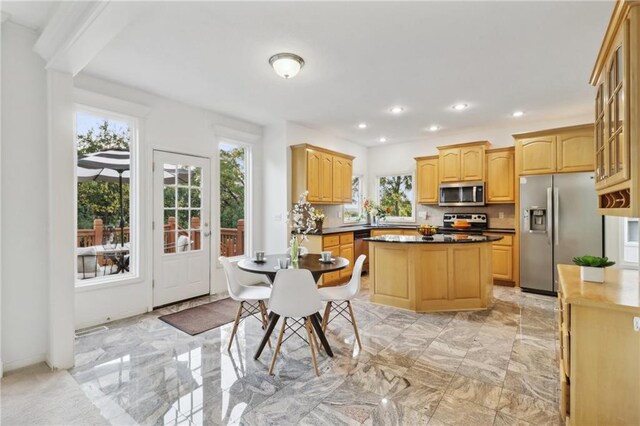 kitchen featuring light brown cabinetry, appliances with stainless steel finishes, sink, and a kitchen island