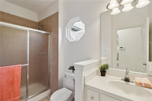 bathroom with vanity, toilet, and a shower with shower door