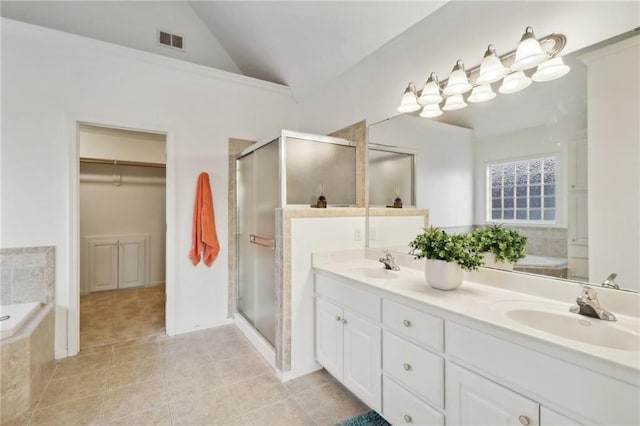 bathroom featuring vanity, separate shower and tub, tile patterned flooring, and vaulted ceiling