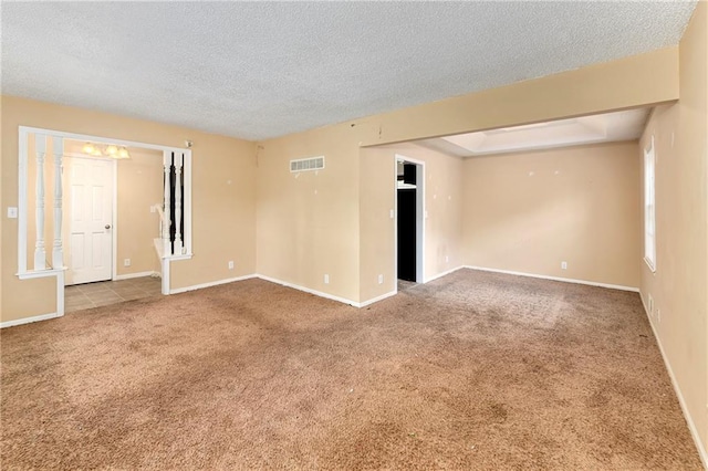 spare room featuring a textured ceiling and carpet flooring