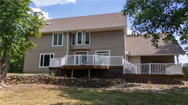 rear view of property featuring a deck and a yard