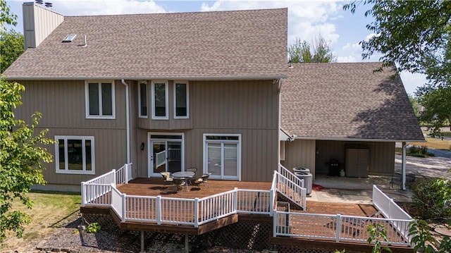 rear view of house featuring cooling unit and a wooden deck