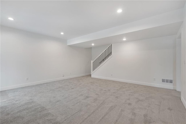 spare room featuring light carpet, recessed lighting, visible vents, and stairway