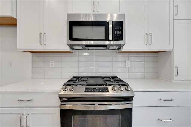 kitchen featuring stainless steel appliances, tasteful backsplash, light countertops, and white cabinets