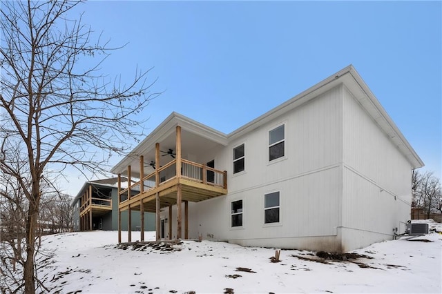 snow covered rear of property with stairs, cooling unit, a deck, and a ceiling fan