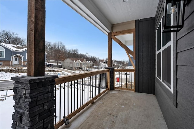 snow covered back of property featuring a residential view