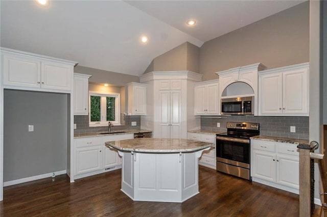 kitchen with white cabinets, stainless steel appliances, and dark hardwood / wood-style floors