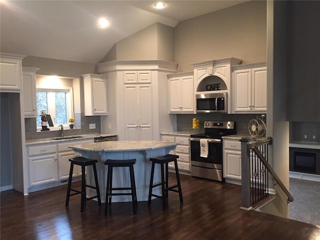 kitchen featuring dark hardwood / wood-style flooring, white cabinetry, backsplash, and appliances with stainless steel finishes