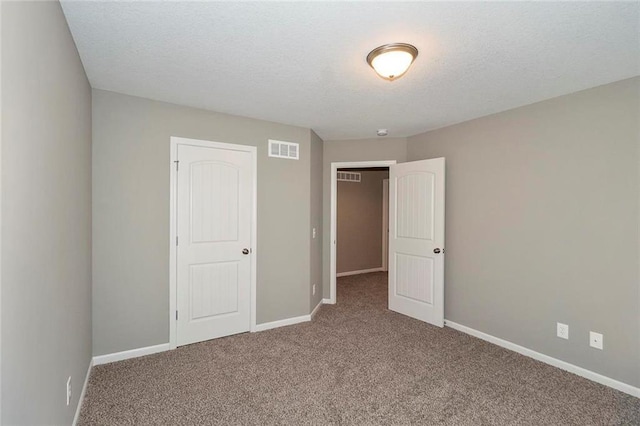 unfurnished bedroom featuring a closet, carpet floors, and a textured ceiling