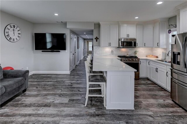 kitchen featuring a wealth of natural light, stainless steel appliances, sink, and white cabinetry