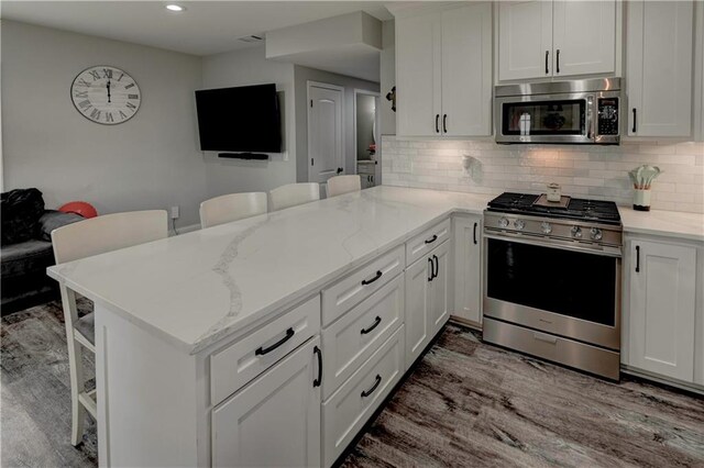 kitchen with stainless steel appliances, kitchen peninsula, and a breakfast bar area