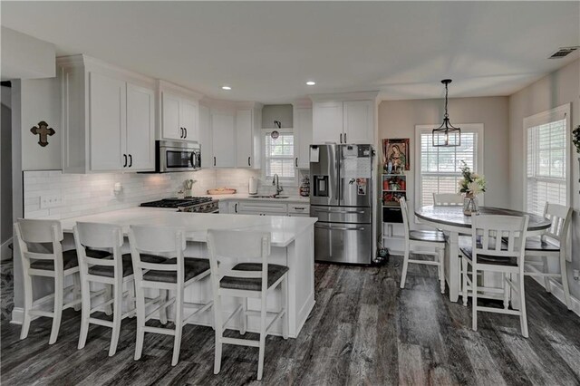 kitchen featuring dark hardwood / wood-style floors, sink, stainless steel appliances, and white cabinets