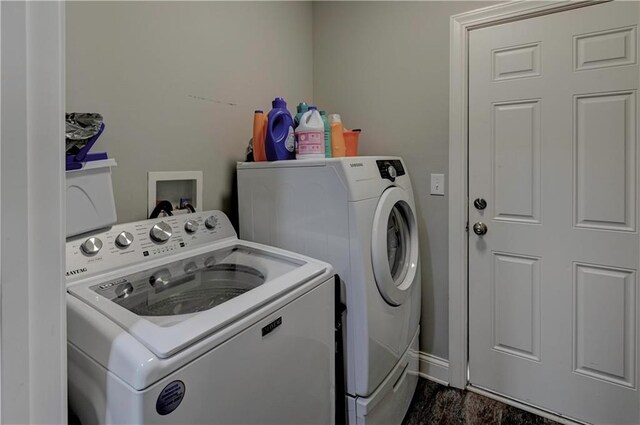 laundry room with dark hardwood / wood-style flooring and washing machine and clothes dryer