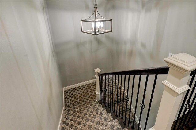 staircase with an inviting chandelier