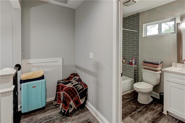 full bathroom featuring wood-type flooring, tiled shower / bath, vanity, and toilet