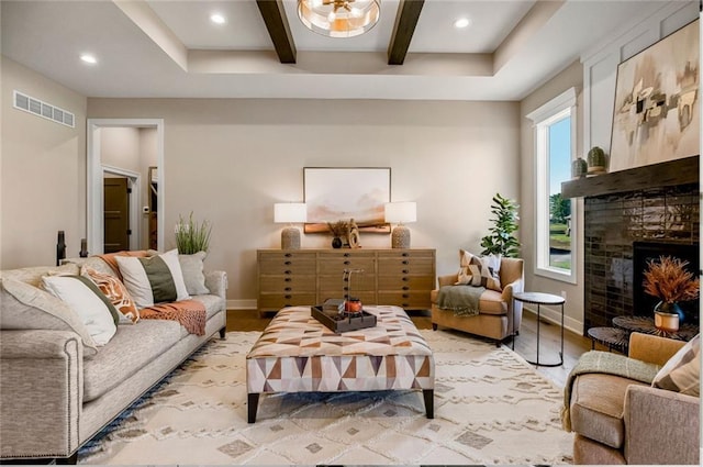 living area featuring light wood-type flooring, visible vents, beam ceiling, and coffered ceiling